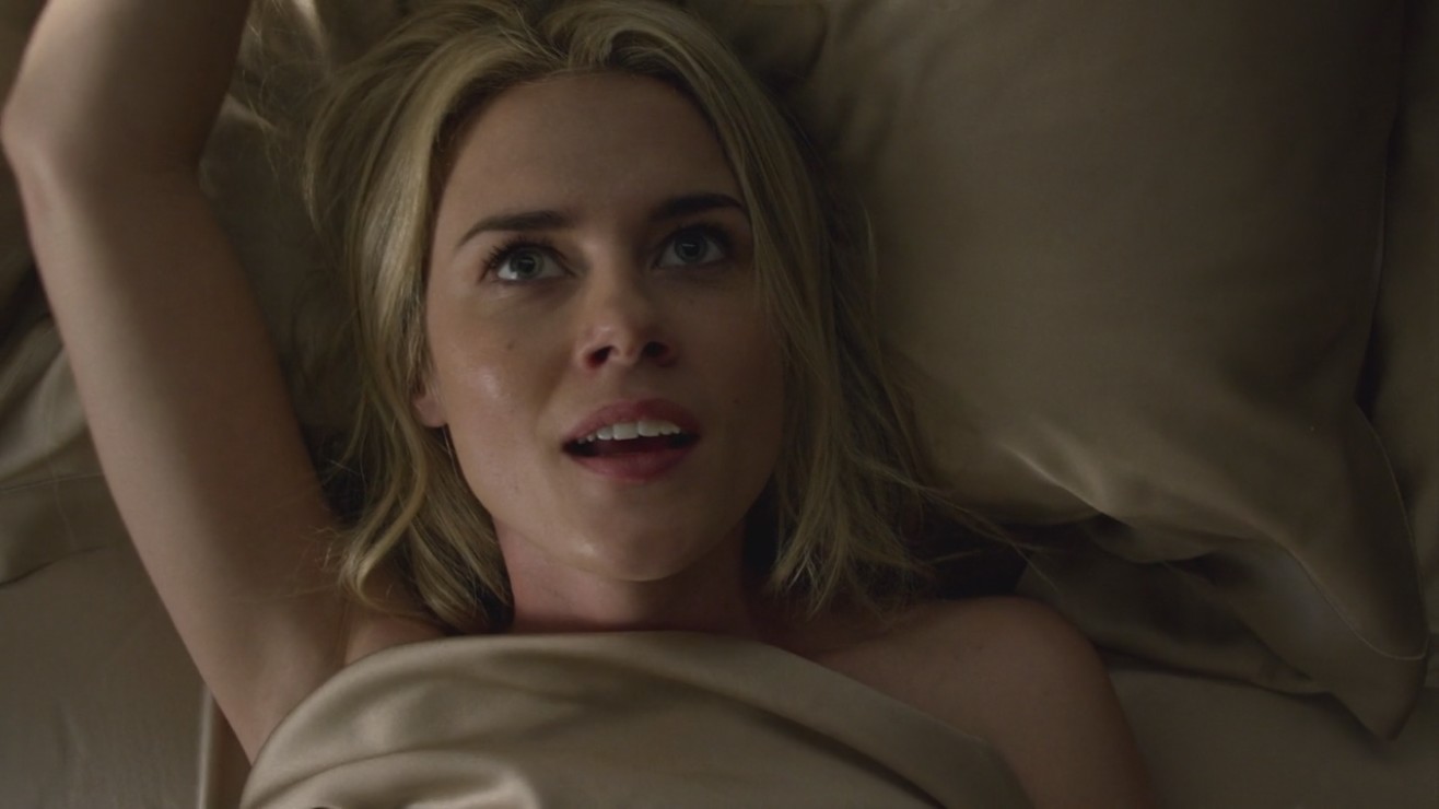 Rachael Taylor is seen in a bed of pale gold satin sheets... 