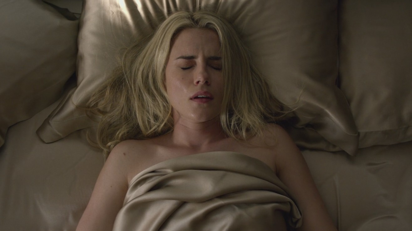 Rachael Taylor is seen in a bed of pale gold satin sheets... 