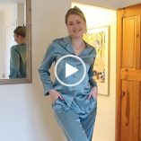 Meg Says stands near the doorway of one of the rooms in her countryside cottage. She wears a pair of teal silk pyjamas. Meg has her blonde hair tied back in a bun. She is seen in light and fresh makeup and a pair of dangling earrings.