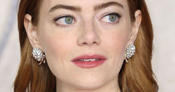 Emma Stone glancing to the side in jewel earrings at the London screening of Poor Things.