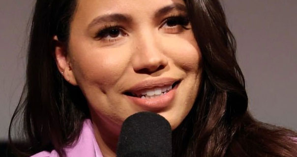Jurnee Smollett wearing a pink blazer and holding a microphone on stage at a screening of The Burial.