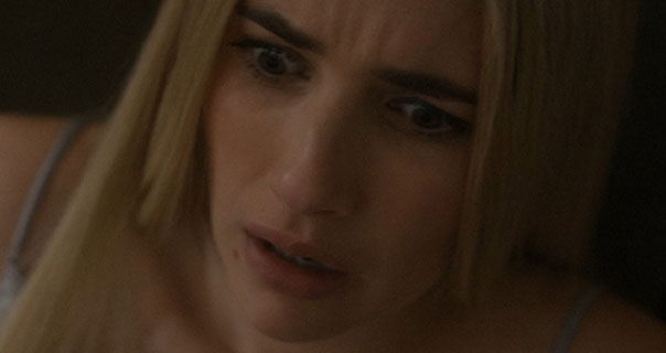 Emma Roberts looks panicked. She wears a powder blue silk and lace camisole top against a dark backround. She has her hair long, straight, loose and cut sharply.