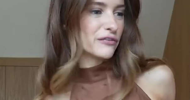 Victoria Magrath appears in her newly refurbished dressing room. She looks to one side while speaking. Her light brown hair has blonde tones and is in natural waves. She wears a brown silk halter dress and a pale pink lipstick. Victoria stands in front of the dark wood wall closets.