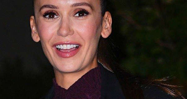 Nina Dobrev is seen in New York City at nighttime. She wears her long black hair tied back in a high ponytail. Nina appears in a black coat and maroon sweater with foundation, blush, mascara and a pink gloss lipstick.