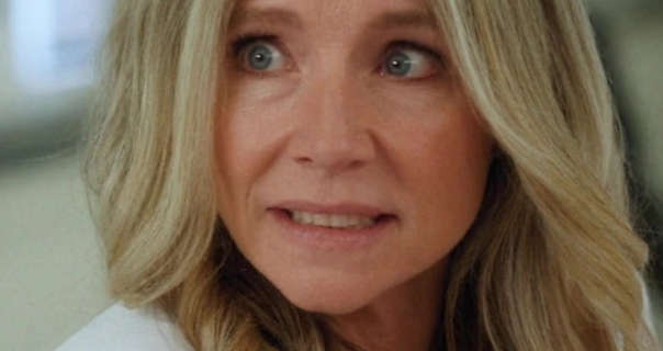 Sarah Chalke appears in an open plan hospital waiting room set. She has her thick blonde hair loose and in soft waves. Sarah wears a light foundation with minimal makeup and a long white lab coat.