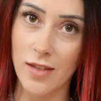 Kirstie Inkorporated is seen with her loose and straightened black hair tinted red at the ends. She stars in a flat foundation, black mascara and a dark pink lipstick.