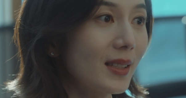 Peng Yan is seen sitting in a skyscraper office in blue daylight. She has her black hair cut to shoulder length and straightened. Peng Yan wears foundation with curled eyelashes, dark pink lipstick and small stud earrings.